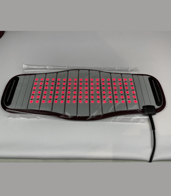 Red light therapy pad with red lights and power cord on gray background