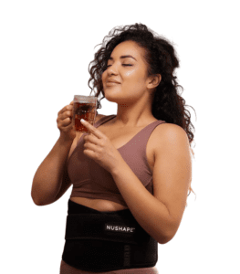 Young woman with eyes closed drinking tea and wearing black belt around waist