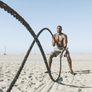 Fit Man on Beach using Battle Ropes