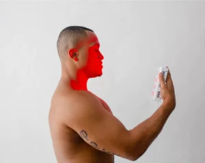 Man using red light thearpy on his face