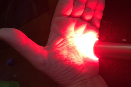 Red light shining on a hand